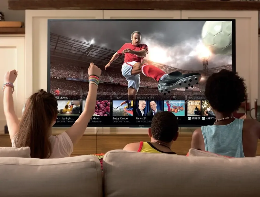 Family watching live football on a big TV at home with a British IPTV subscription